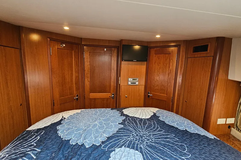  Yacht Photos Pics Interior of 2007 Silverton 38 Sport Bridge with wood paneling and floral bedspread.