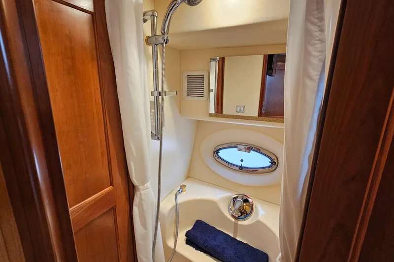  Yacht Photos Pics Shower area in 2007 Silverton 38 Sport Bridge yacht with wooden accents and porthole window.