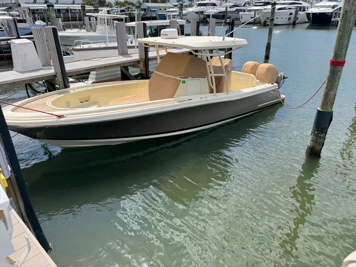  Yacht Photos Pics 2018 Chris-Craft Catalina 30 docked in a marina, surrounded by water and other boats.