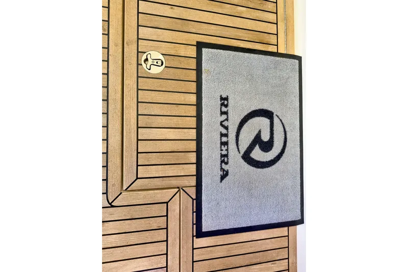  Yacht Photos Pics Gray Riviera doormat on wooden deck of 2020 Riviera 4800 Sport Yacht.