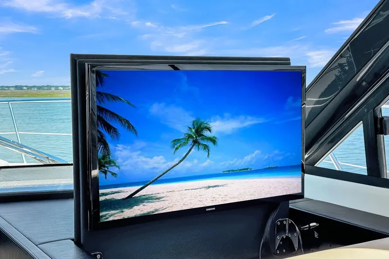  Yacht Photos Pics Flat-screen TV on 2020 Riviera 4800 Sport Yacht, displaying tropical beach scene.