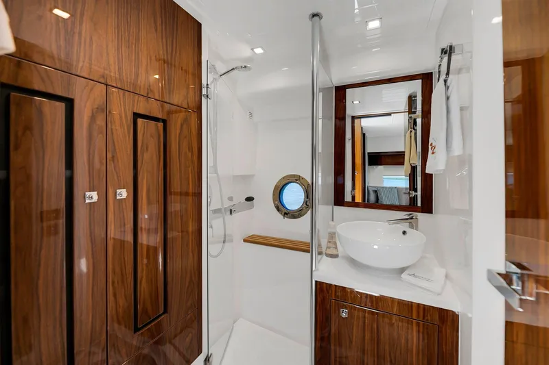  Yacht Photos Pics Luxurious bathroom in 2020 Riviera 4800 Sport Yacht with wood accents and modern fixtures.