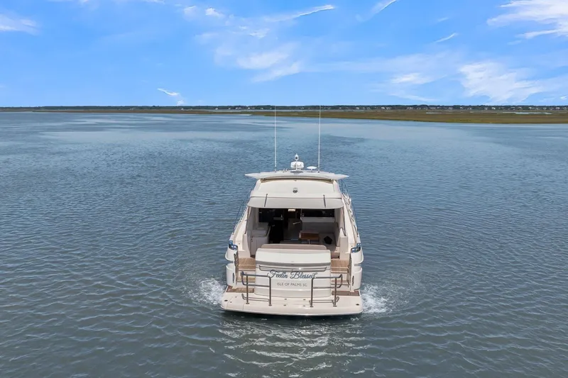  Yacht Photos Pics 2020 Riviera 4800 Sport Yacht cruising on calm waters under a clear blue sky.