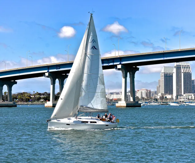 Bonejour Yacht Photos Pics Sailing yacht Hanse 385 (2012) under a bridge with city skyline in the background.