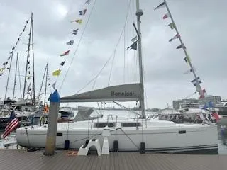Bonejour Yacht Photos Pics Sailboat Hanse 385, 2012 model, docked with colorful flags on a cloudy day.