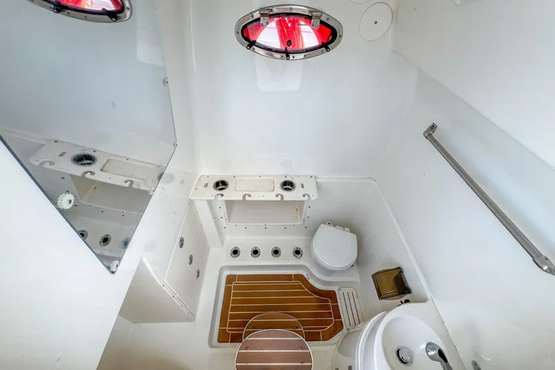  Yacht Photos Pics 2008 Triton 351 CC boat bathroom with toilet, sink, and wooden floor mat.