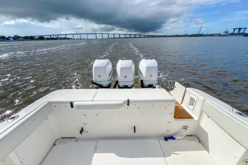  Yacht Photos Pics 2008 Triton 351 CC boat with triple engines cruising under cloudy skies.