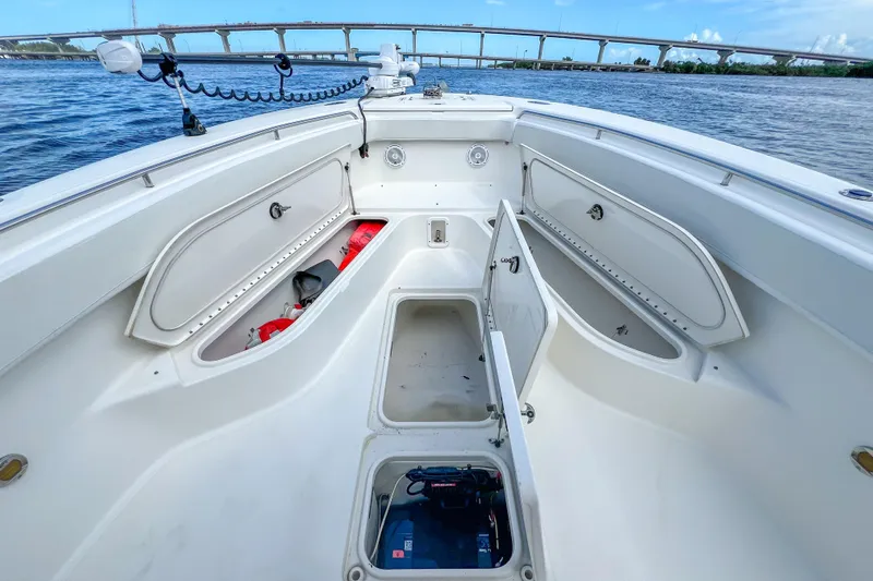  Yacht Photos Pics 2008 Triton 351 CC boat interior with open storage compartments, on a calm waterway.