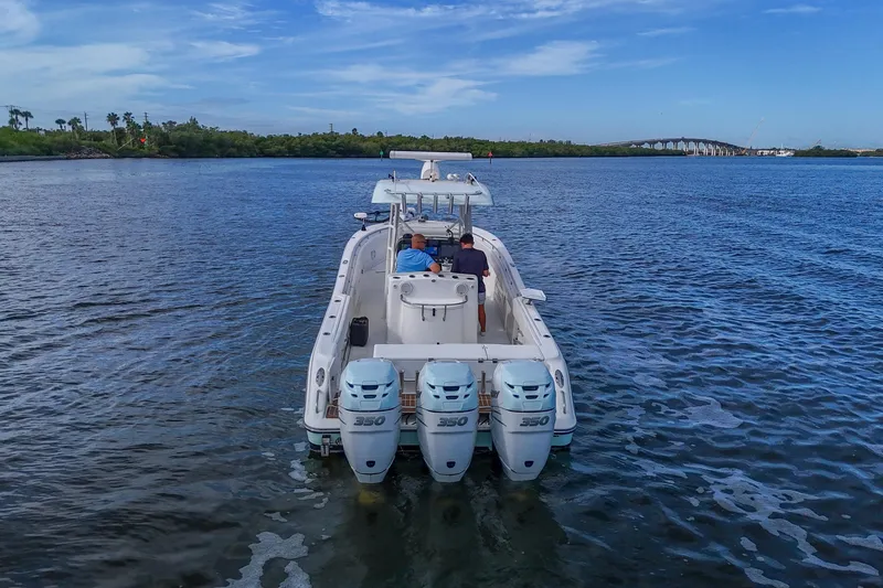  Yacht Photos Pics 2008 Triton 351 CC boat with triple 350 engines cruising on a calm waterway.