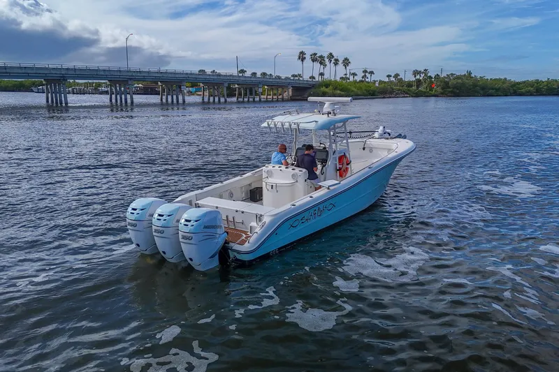  Yacht Photos Pics 2008 Triton 351 CC boat cruising on a scenic waterway near a bridge.
