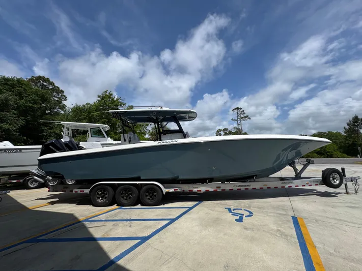  Yacht Photos Pics 2021 Fountain 38TE boat on trailer, parked outdoors under a cloudy sky.