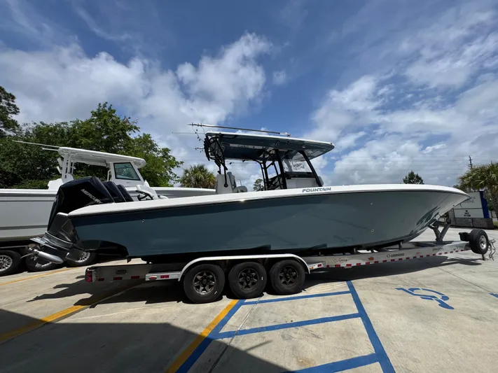  Yacht Photos Pics 2021 Fountain 38TE boat on trailer under cloudy sky.