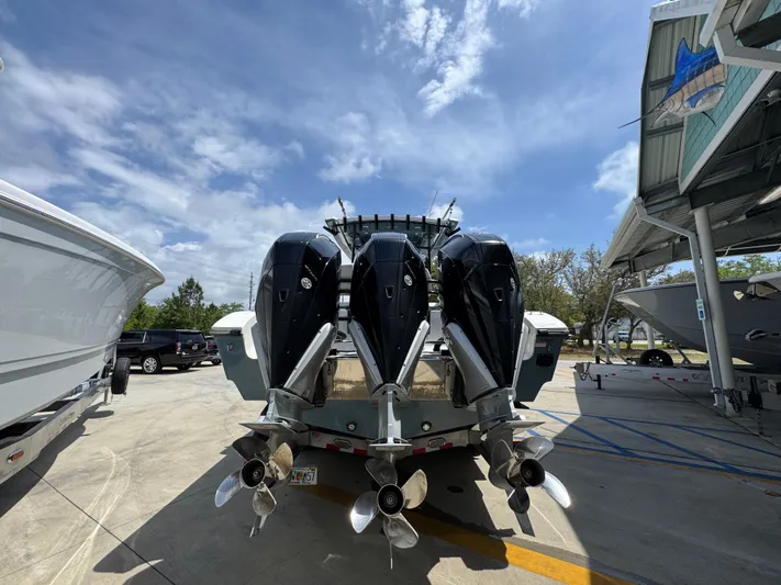  Yacht Photos Pics 2021 Fountain 38TE boat with triple outboard engines in a marina setting.