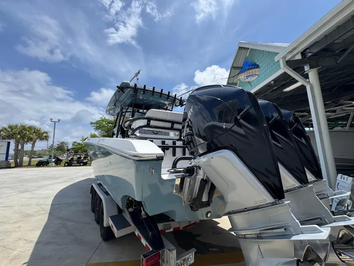  Yacht Photos Pics 2021 Fountain 38TE boat with powerful outboard engines, parked outdoors under a clear sky.