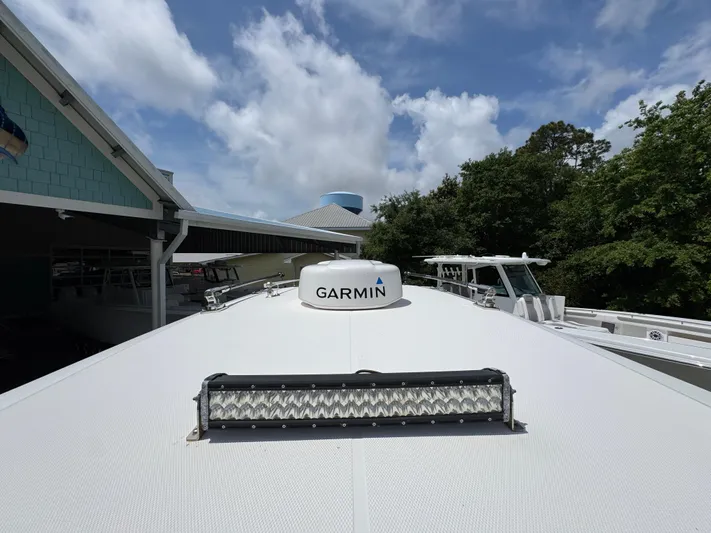  Yacht Photos Pics 2021 Fountain 38TE boat with Garmin radar, docked under a cloudy sky.