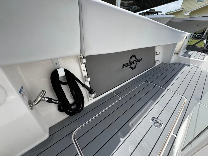  Yacht Photos Pics 2021 Fountain 38TE boat deck with logo, featuring sleek gray flooring and coiled rope.