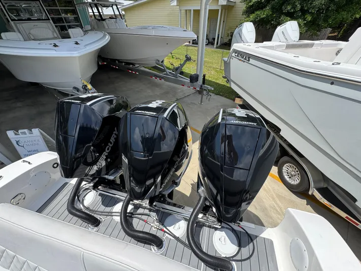  Yacht Photos Pics Triple Mercury outboard engines on a 2021 Fountain 38TE boat, docked with other vessels.