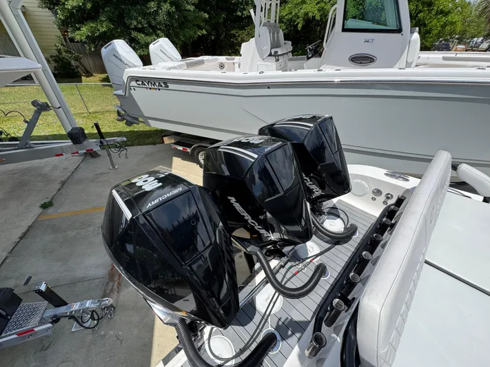 Yacht Photos Pics Triple outboard motors on a 2021 Fountain 38TE boat, parked near a trailer.