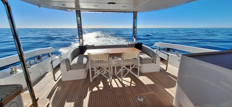 Nassara Yacht Photos Pics Luxurious 2023 Azimut 78 yacht deck with seating, table, and ocean view.