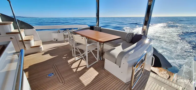 Nassara Yacht Photos Pics Luxurious 2023 Azimut 78 yacht deck with seating, table, and ocean view.