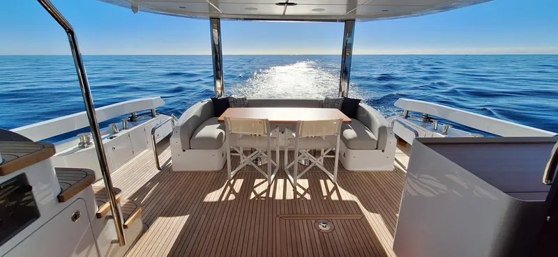 Nassara Yacht Photos Pics Azimut 78 yacht deck with seating and table, cruising on open sea, 2023 model.