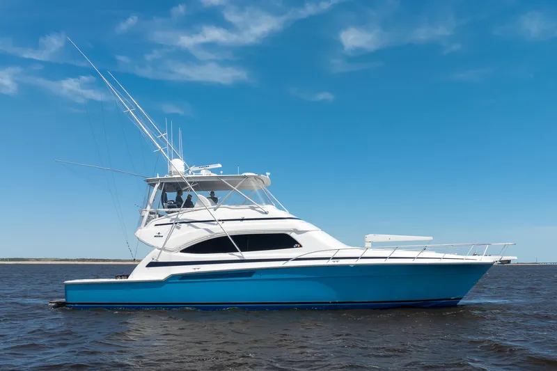 Dock Side Yacht Photos Pics 2007 Bertram 570 Convertible yacht cruising on open water under clear blue sky.
