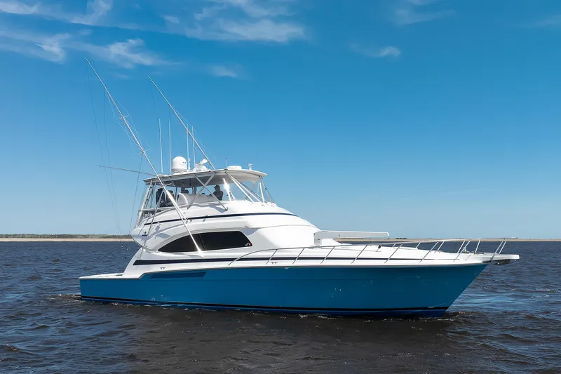 Dock Side Yacht Photos Pics 2007 Bertram 570 Convertible yacht cruising on open water under clear blue sky.