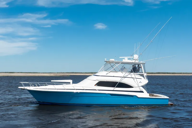 Dock Side Yacht Photos Pics 2007 Bertram 570 Convertible yacht on open water under clear blue sky.
