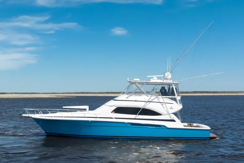 Dock Side Yacht Photos Pics 2007 Bertram 570 Convertible yacht cruising on open water under clear blue skies.