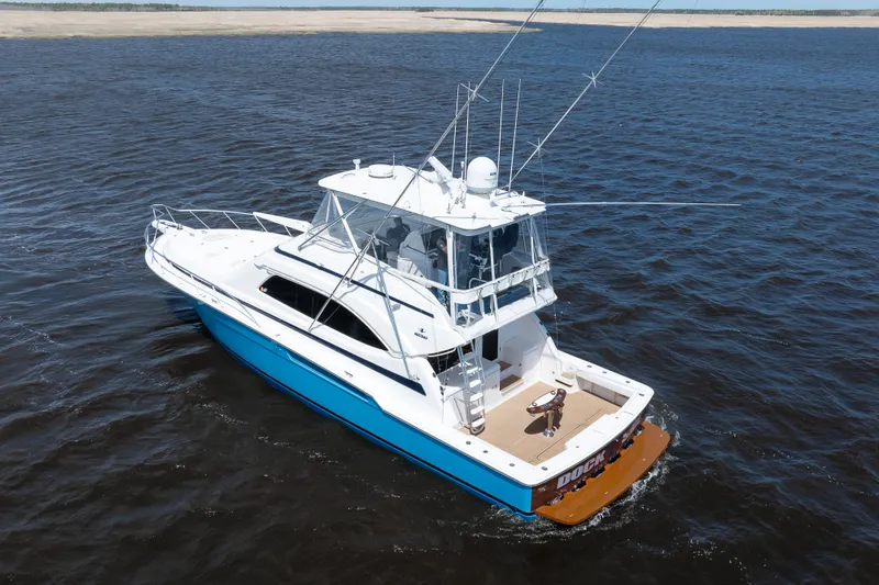 Dock Side Yacht Photos Pics 2007 Bertram 570 Convertible yacht cruising on open water, showcasing sleek design and fishing equipment.