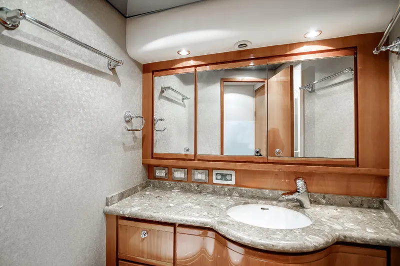 Dock Side Yacht Photos Pics Luxurious bathroom in 2007 Bertram 570 Convertible yacht with marble countertop and wooden cabinetry.