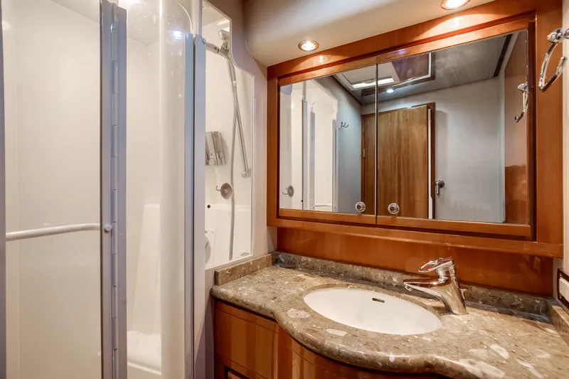 Dock Side Yacht Photos Pics Luxurious bathroom in 2007 Bertram 570 Convertible yacht with modern fixtures and elegant design.