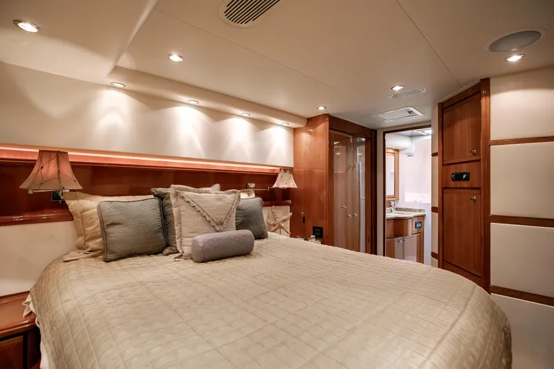 Dock Side Yacht Photos Pics Luxurious bedroom interior of 2007 Bertram 570 Convertible yacht with elegant lighting and wood finishes.