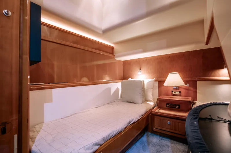 Dock Side Yacht Photos Pics Luxurious cabin interior of 2007 Bertram 570 Convertible yacht with cozy bed and warm lighting.