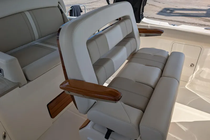  Yacht Photos Pics Luxury seating on 2024 Boston Whaler 350 Realm boat, featuring plush cushions and wooden armrests.
