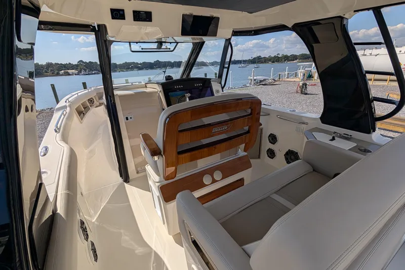  Yacht Photos Pics 2024 Boston Whaler 350 Realm interior with helm, luxurious seating, and waterfront view.