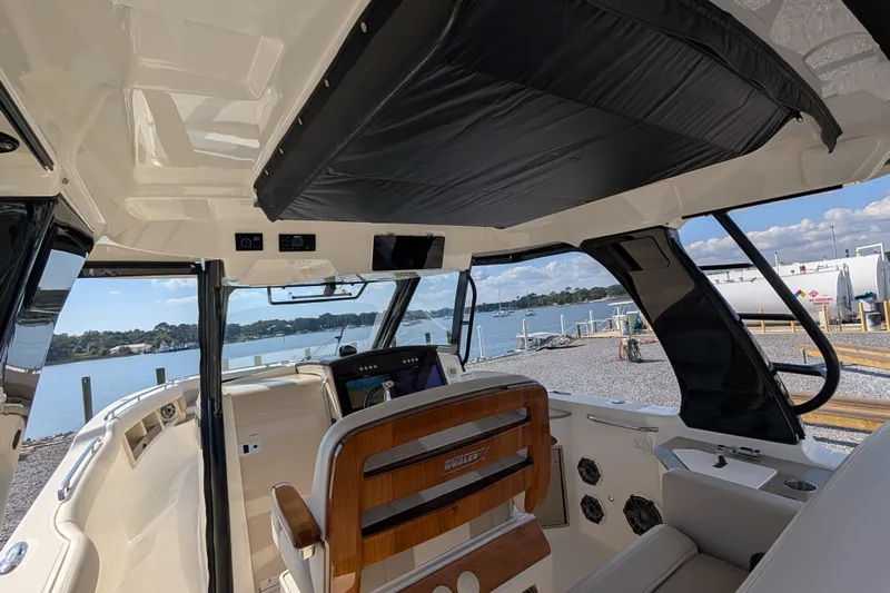  Yacht Photos Pics 2024 Boston Whaler 350 Realm interior with helm view, dockside, under sunny skies.