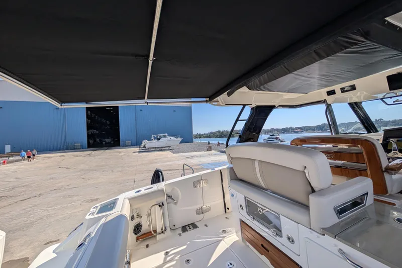  Yacht Photos Pics 2024 Boston Whaler 350 Realm interior view at marina with blue warehouse background.
