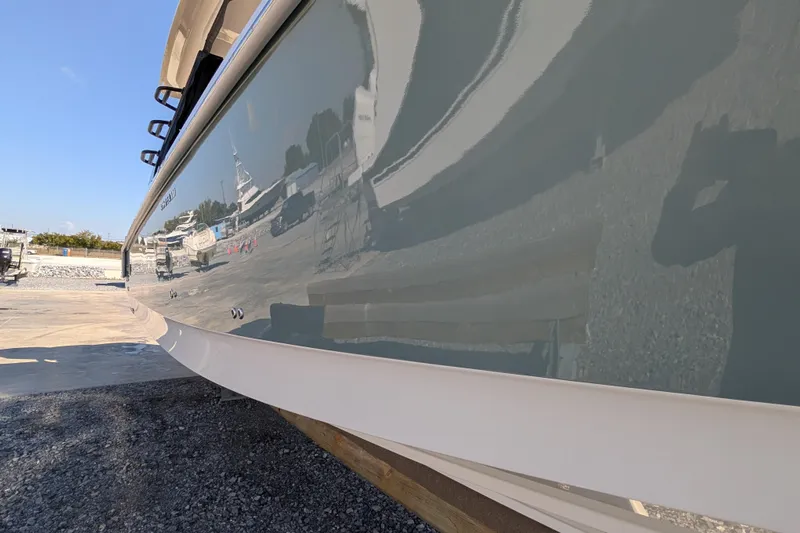  Yacht Photos Pics 2024 Boston Whaler 350 Realm boat hull reflecting surroundings in a marina setting.