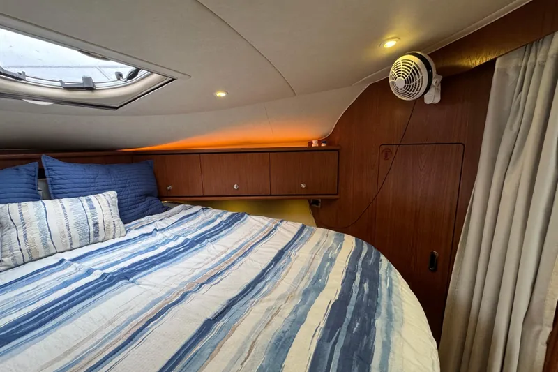  Yacht Photos Pics Cozy cabin interior of 2008 Tiara Yachts 3900 Sovran with striped bedding and wood paneling.