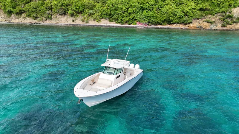  Yacht Photos Pics 2013 Grady-White Canyon 366 boat on clear turquoise water near lush green shoreline.
