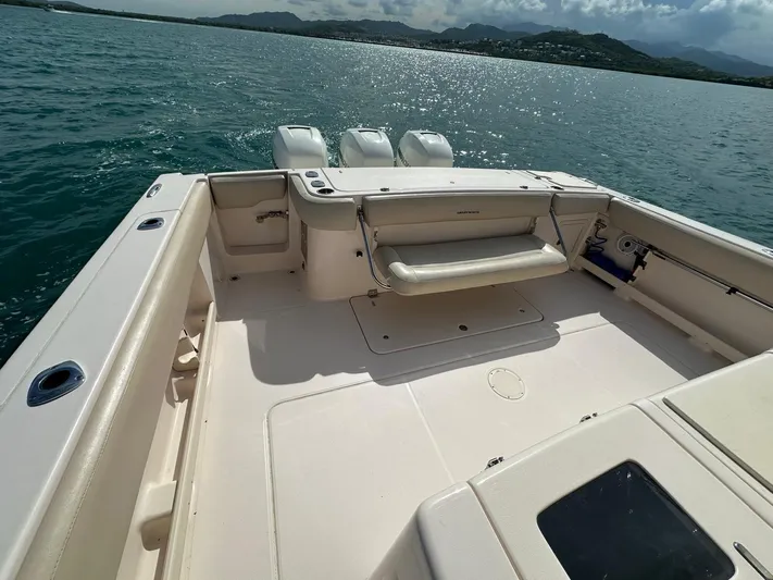 Yacht Photos Pics 2013 Grady-White Canyon 366 boat deck with triple outboard engines on calm water.