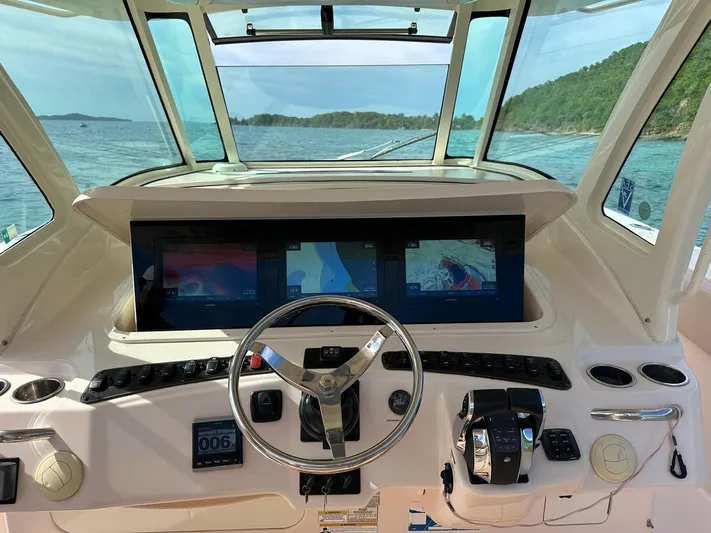  Yacht Photos Pics Grady-White Canyon 366 helm with advanced navigation screens, steering wheel, and ocean view.