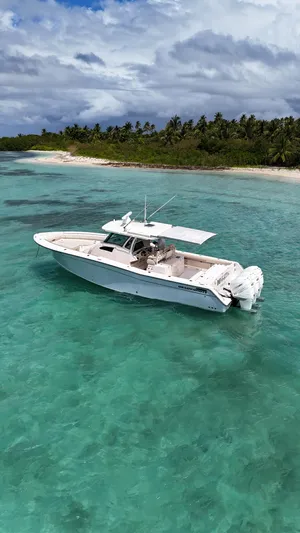  Yacht Photos Pics 2013 Grady-White Canyon 366 boat on turquoise water near tropical island.