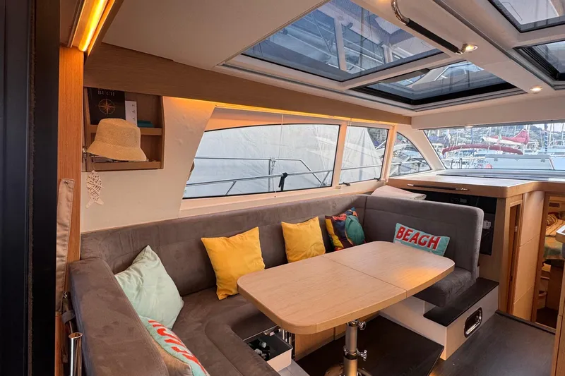 Annie Yacht Photos Pics Luxurious interior of 2023 Nimbus 405 Coup&eacute; yacht with cozy seating and decorative pillows.