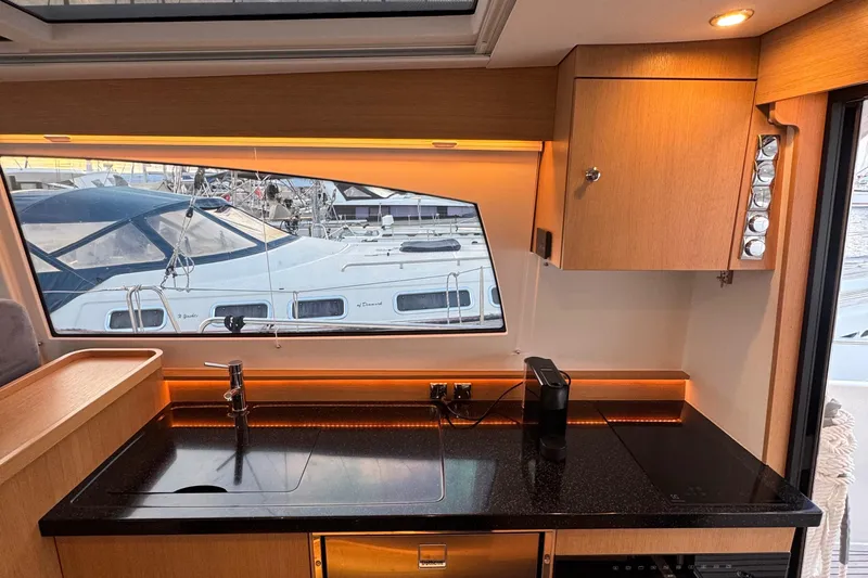 Annie Yacht Photos Pics Interior of 2023 Nimbus 405 Coup&eacute; yacht with sleek kitchen and marina view.