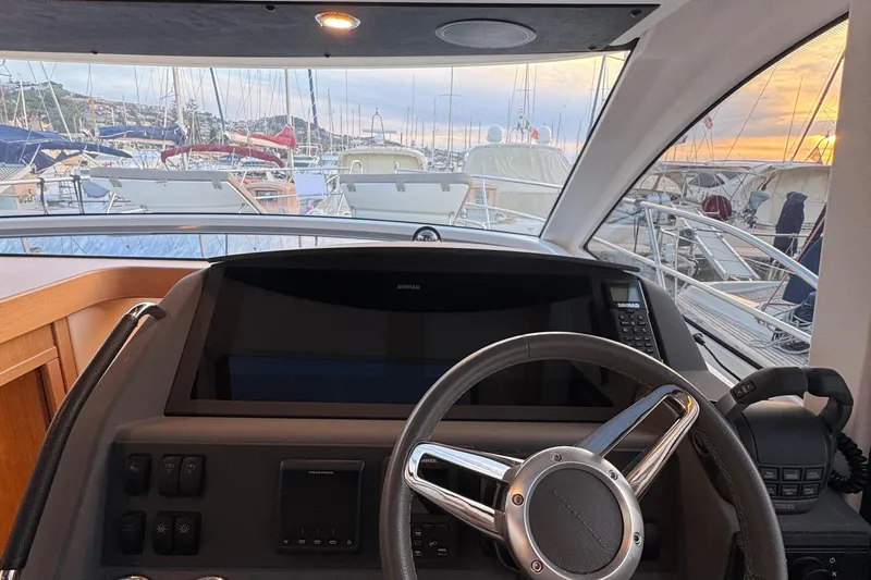 Annie Yacht Photos Pics Helm of 2023 Nimbus 405 Coup&eacute; yacht with marina view at sunset.