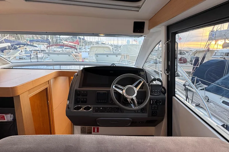 Annie Yacht Photos Pics Interior view of 2023 Nimbus 405 Coup&eacute; helm with marina background.