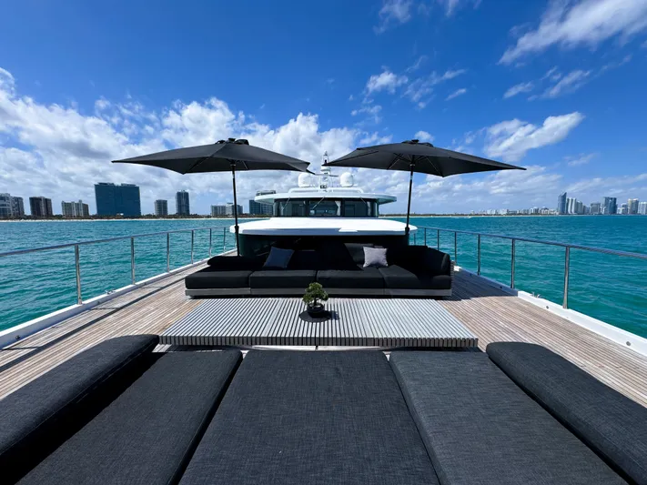  Yacht Photos Pics Luxurious 2010 Custom WHS Marine yacht with sun loungers and umbrellas on deck, city skyline in background.