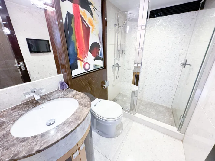  Yacht Photos Pics Luxurious yacht bathroom with modern fixtures, marble countertop, and glass shower enclosure.